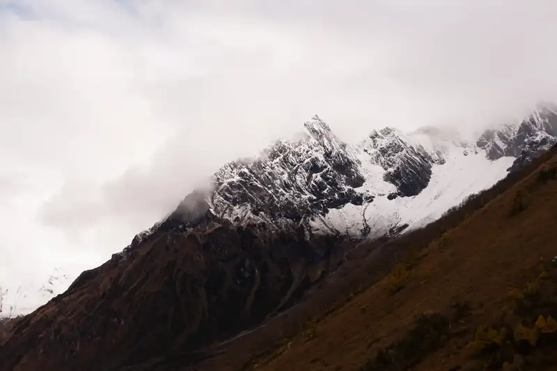 A snow-covered Himalayan mountain ridge above a dark slope.